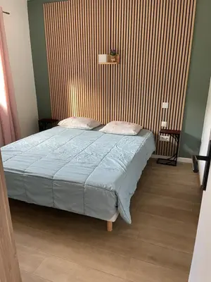 a bedroom with a bed with a blue comforter at Appart Sylvie B in Porto-Vecchio