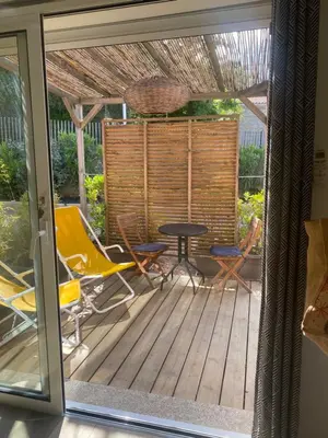 a patio with chairs and a table on a deck at Appart Sylvie B in Porto-Vecchio