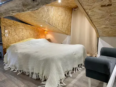 a bedroom with a white bed and two chairs at Appartement 1 chambre en Haute-Corse à Pietra Di Verde in Pietra-di-Verde