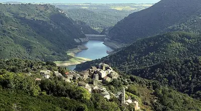 a small town on a hill with a river in a valley at Appartement 1 chambre en Haute-Corse à Pietra Di Verde in Pietra-di-Verde