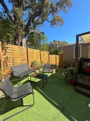 a backyard with three chairs and a table and a fence at A Casa Di l'Altana in Porto-Vecchio