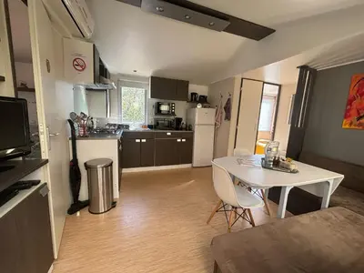 a kitchen with a table and a white table and chairs at A Casa Di l'Altana in Porto-Vecchio