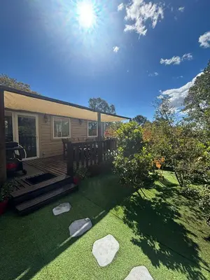 a backyard with a deck and a lawn with rocks at A Casa Di l'Altana in Porto-Vecchio
