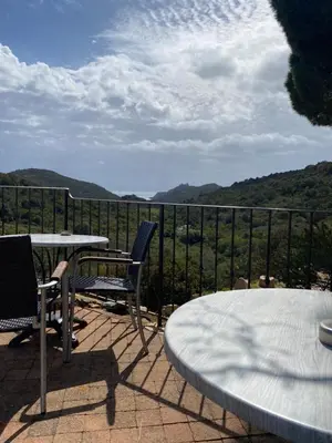 a patio with a table and chairs and a view at Auberge Coralli in Sartène