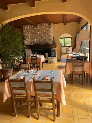 a dining room with a table and a fireplace at Auberge Coralli in Sartène