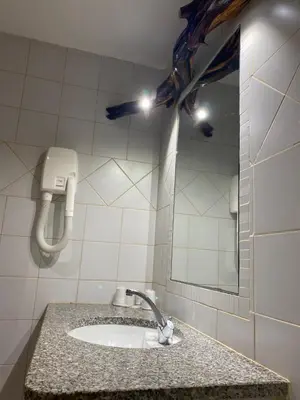 a bathroom with a sink and a blue umbrella at Auberge Coralli in Sartène