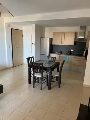 a kitchen with a dining room table and chairs at Superbe appartement avec parking privé, proche commerces et mer in Lucciana
