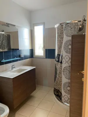 a bathroom with a sink and a shower curtain at Superbe appartement avec parking privé, proche commerces et mer in Lucciana
