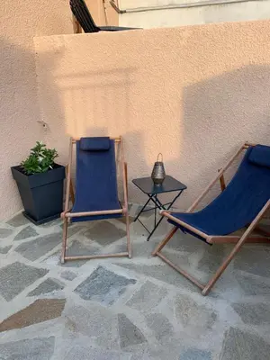two chairs and a table next to a wall at Levé du soleil sur la mer in Taglio-Isolaccio
