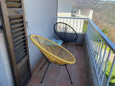 a couple of chairs sitting on a balcony at Levé du soleil sur la mer in Taglio-Isolaccio
