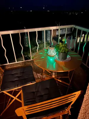 a table and chairs on a balcony at night at Levé du soleil sur la mer in Taglio-Isolaccio