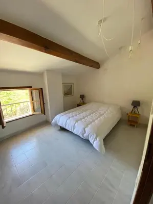 a bedroom with a bed in a room with a window at Levé du soleil sur la mer in Taglio-Isolaccio