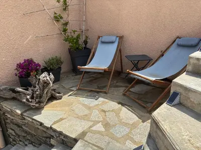 two blue chairs sitting on a patio with plants at Levé du soleil sur la mer in Taglio-Isolaccio