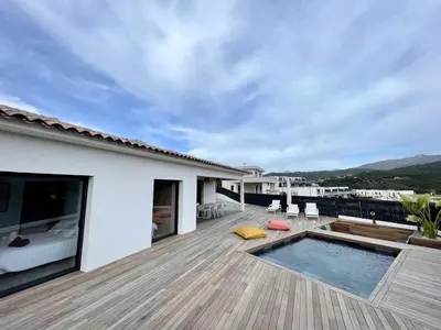 a deck with a swimming pool and a house at Villa U Pastore in Porticcio