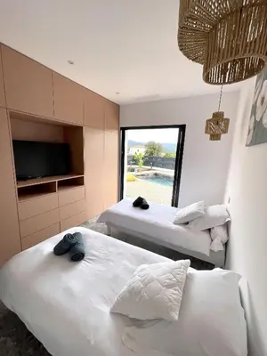 two beds in a room with a tv at Villa U Pastore in Porticcio