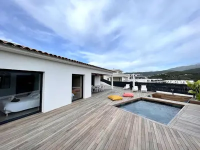 a deck with a pool and a bed on a house at Villa U Pastore in Porticcio