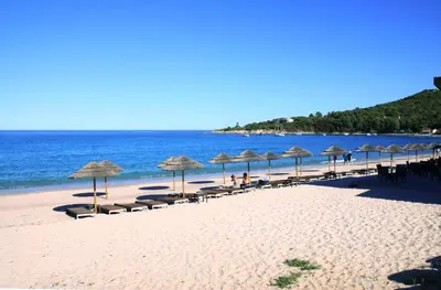 a beach with umbrellas and chairs and the ocean at Apartment Porto Vecchio, 6 persons, 500 m beach in Zonza