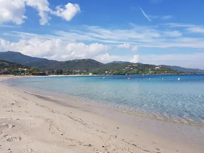 a beach with blue water and mountains in the background at Apartment Porto Vecchio, 6 persons, 500 m beach in Zonza