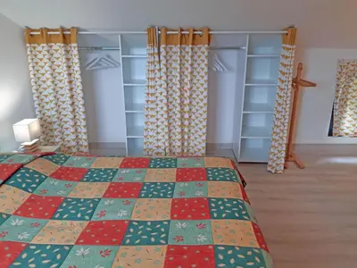 a bedroom with a bed with a colorful quilt at Douceur du soir - Duplex 45m2 - Terrasse - Jardinet - Wifi fibre - Plage à pied in Porticcio