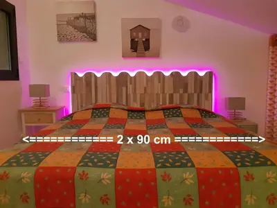 a bedroom with a bed with a colorful quilt at Douceur du soir - Duplex 45m2 - Terrasse - Jardinet - Wifi fibre - Plage à pied in Porticcio