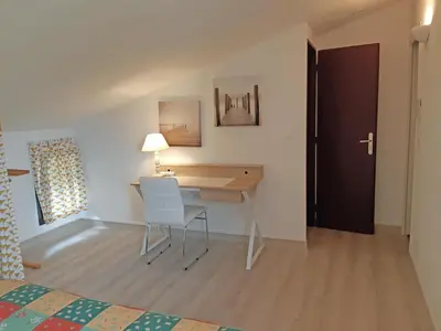 a bedroom with a desk with a chair and a bed at Douceur du soir - Duplex 45m2 - Terrasse - Jardinet - Wifi fibre - Plage à pied in Porticcio