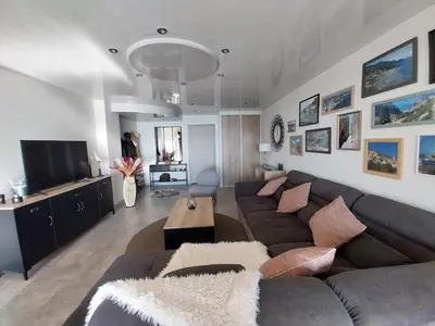 a living room with a couch and a tv at Résidence Les Marines de Moriani pieds dans l'eau duplex avec terrasses vue mer, 4-8 pers in San-Nicolao