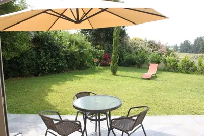 a table and chairs under an umbrella on a patio at E Cabanacce in Aléria