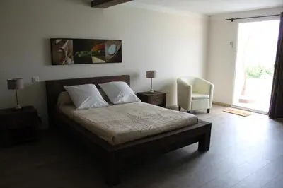 a bedroom with a bed and a chair and a window at E Cabanacce in Aléria