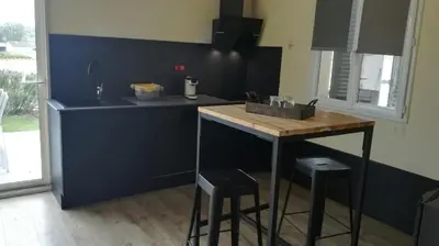 a kitchen with a sink and a counter with stools at E Cabanacce in Aléria