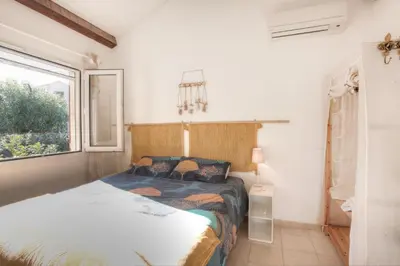 a bedroom with a bed and a window at Kazamasavani - Belle maison proche mer in Cervione