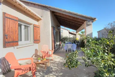 a patio with chairs and a table in a house at Kazamasavani - Belle maison proche mer in Cervione