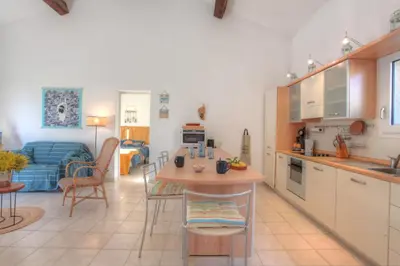 a kitchen and living room with a table and chairs at Kazamasavani - Belle maison proche mer in Cervione