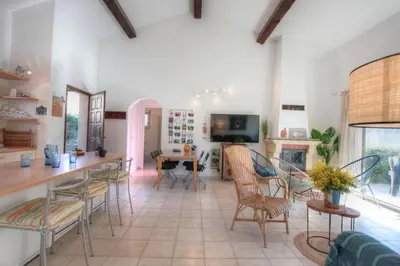 a living room with a table and chairs and a fireplace at Kazamasavani - Belle maison proche mer in Cervione