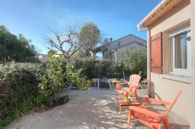 a patio with two chairs and a table in a yard at Kazamasavani - Belle maison proche mer in Cervione