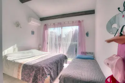a small bedroom with a bed and a window at Kazamasavani - Belle maison proche mer in Cervione