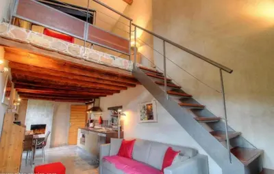 a living room with a staircase and a couch at Entre mer & maquis, l'âme de la Corse en gîtes de charme avec jacuzzi, proche Ajaccio in Peri