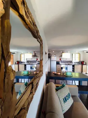 a living room with a couch and a kitchen at Entre mer & maquis, l'âme de la Corse en gîtes de charme avec jacuzzi, proche Ajaccio in Peri