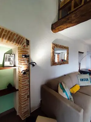 a living room with a couch and a mirror at Entre mer & maquis, l'âme de la Corse en gîtes de charme avec jacuzzi, proche Ajaccio in Peri