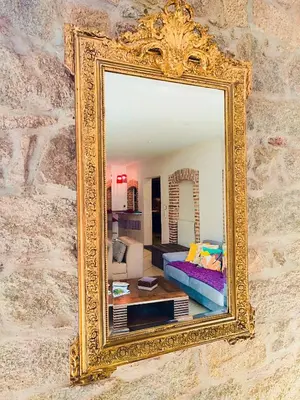 a gold mirror hanging on a wall with a living room at T3 de 140m2 pour 7 pers- Extra centre Ajaccio - À 5 min à pied des plages - Classé 5 étoiles - CASA DI ARTISTI in Ajaccio