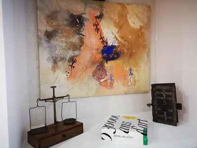 a cross and a book on a table with a painting at T3 de 140m2 pour 7 pers- Extra centre Ajaccio - À 5 min à pied des plages - Classé 5 étoiles - CASA DI ARTISTI in Ajaccio