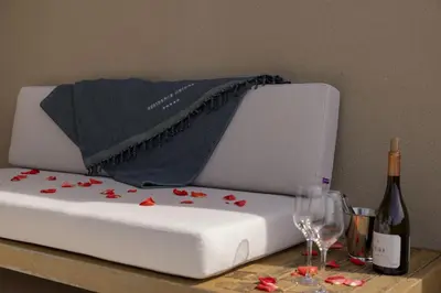 a white mattress with flowers on it with a bottle of wine at Résidence Omigna in Cargèse