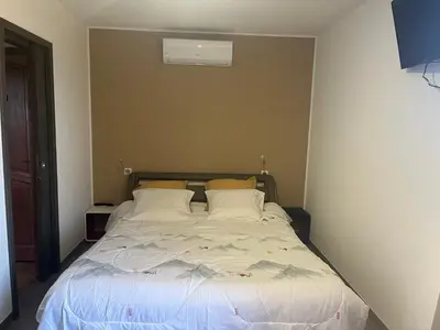 a bedroom with a bed with white sheets and pillows at IN'D'NOI in Ajaccio