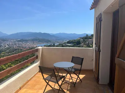 a table and two chairs on a balcony with a view at IN'D'NOI in Ajaccio