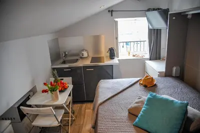 a small room with a bed and a small kitchen at Les Studios du Pêcheur - Hypercentre - Clim - City Trip in Ajaccio