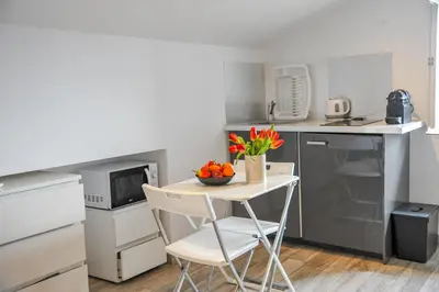 a small kitchen with a small table with flowers on it at Les Studios du Pêcheur - Hypercentre - Clim - City Trip in Ajaccio