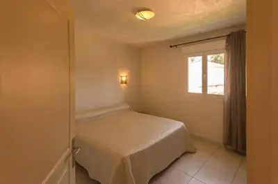 a small bedroom with a bed and a window at Residence de tourisme Le clos des Vendanges in Moriani Plage