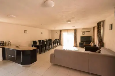 a large kitchen with a refrigerator and a sink at Residence de tourisme Le clos des Vendanges in Moriani Plage