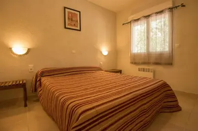 a living room with a couch and a table and chairs at Residence de tourisme Le clos des Vendanges in Moriani Plage