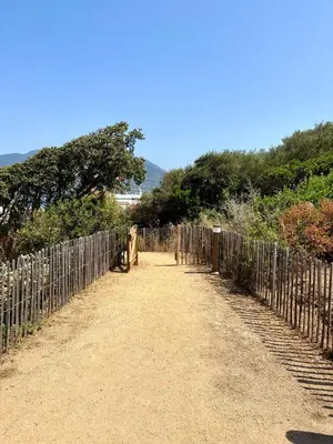 a fence on the side of a dirt road at APPART-NEUF-VUE MER- 6 PERS in Propriano