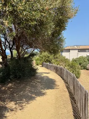 a fence next to a dirt road with trees at APPART-NEUF-VUE MER- 6 PERS in Propriano